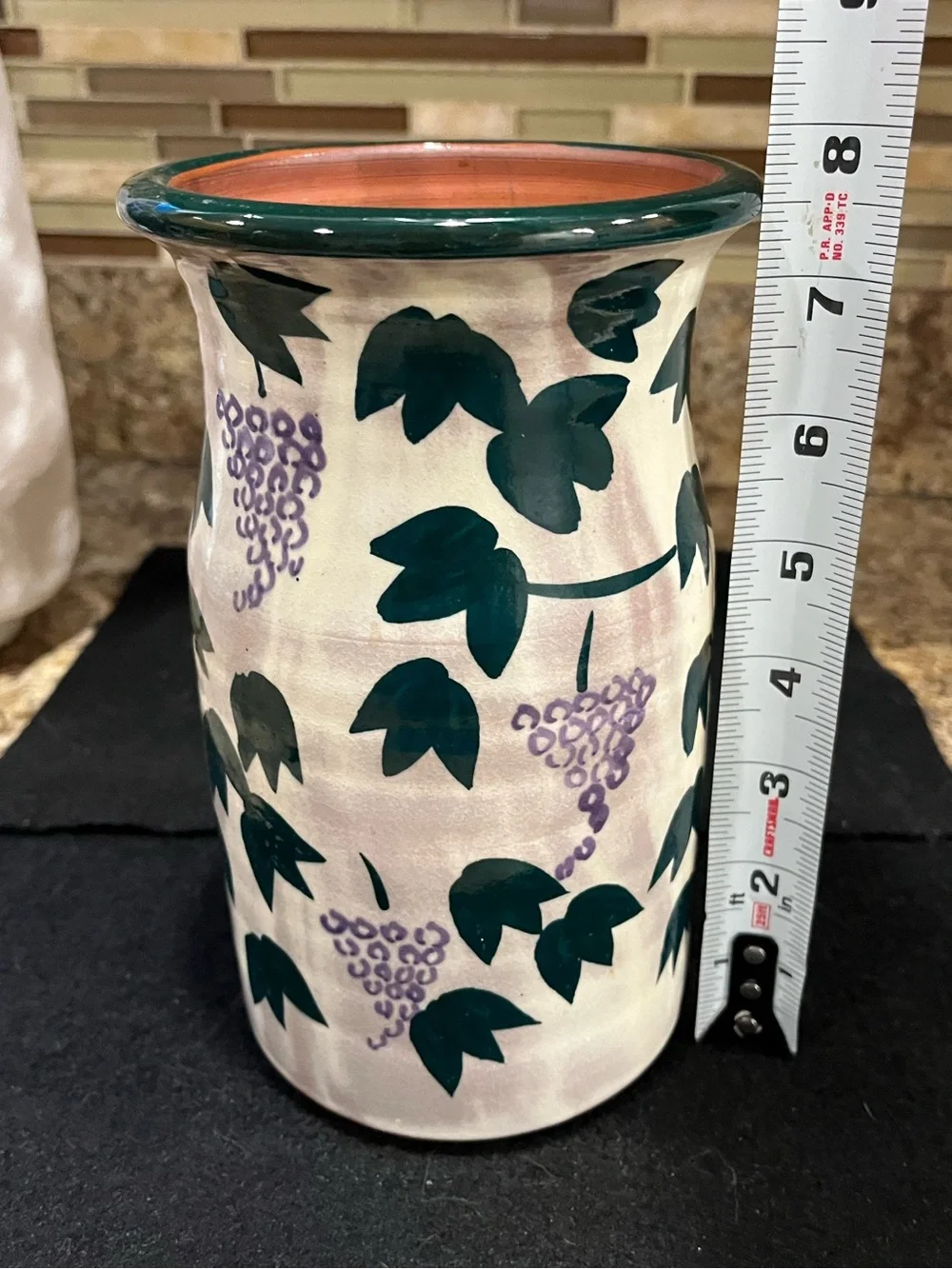 Handmade pottery vase cream-colored with a green and purple grape vine motif
